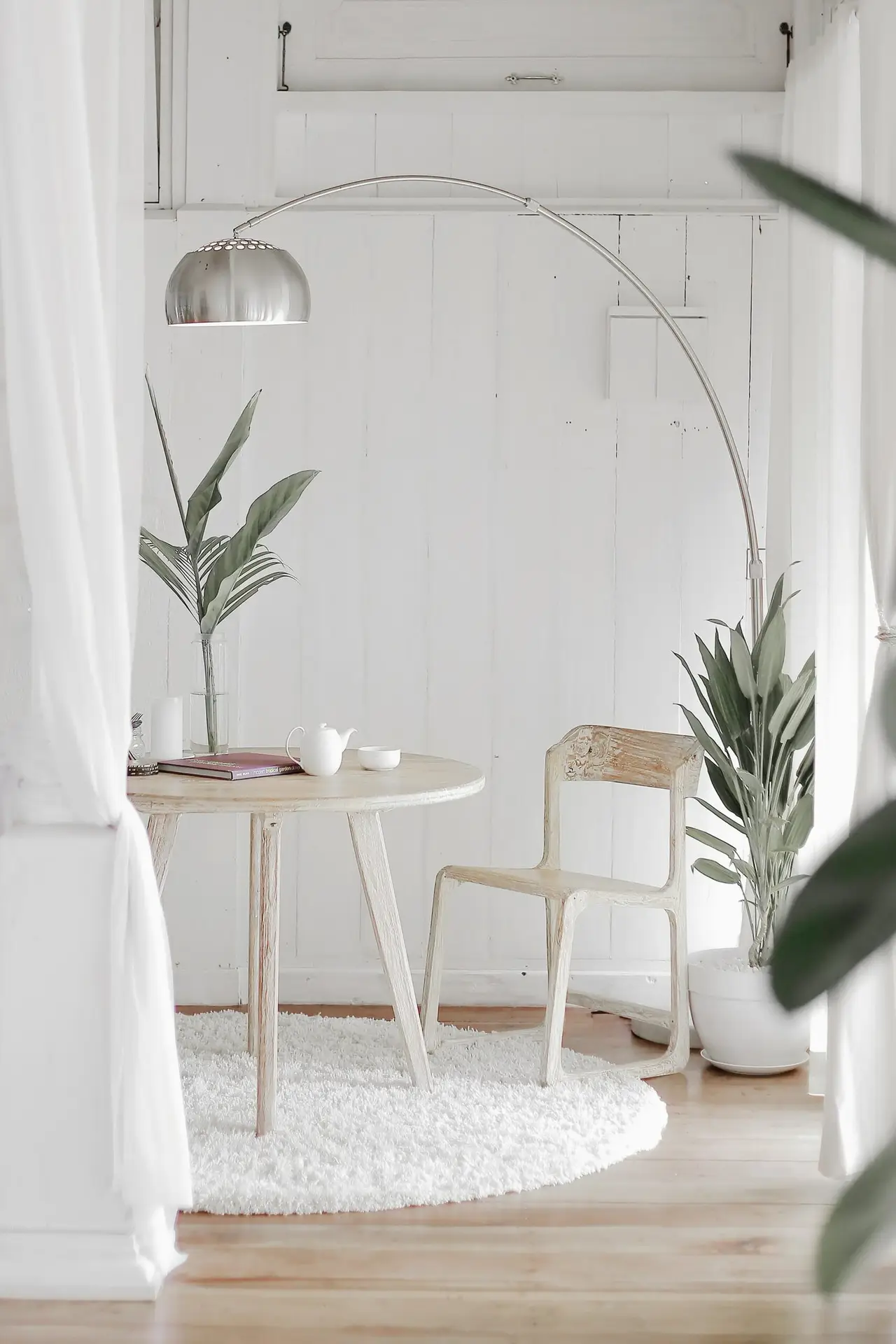 white steel chair in front round table on white rug